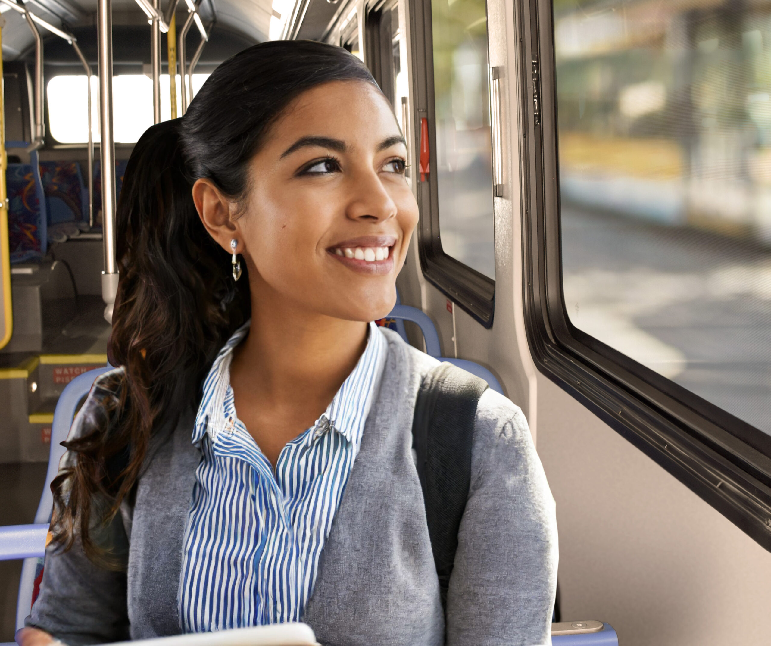 Happy Hispanic female riding the bus