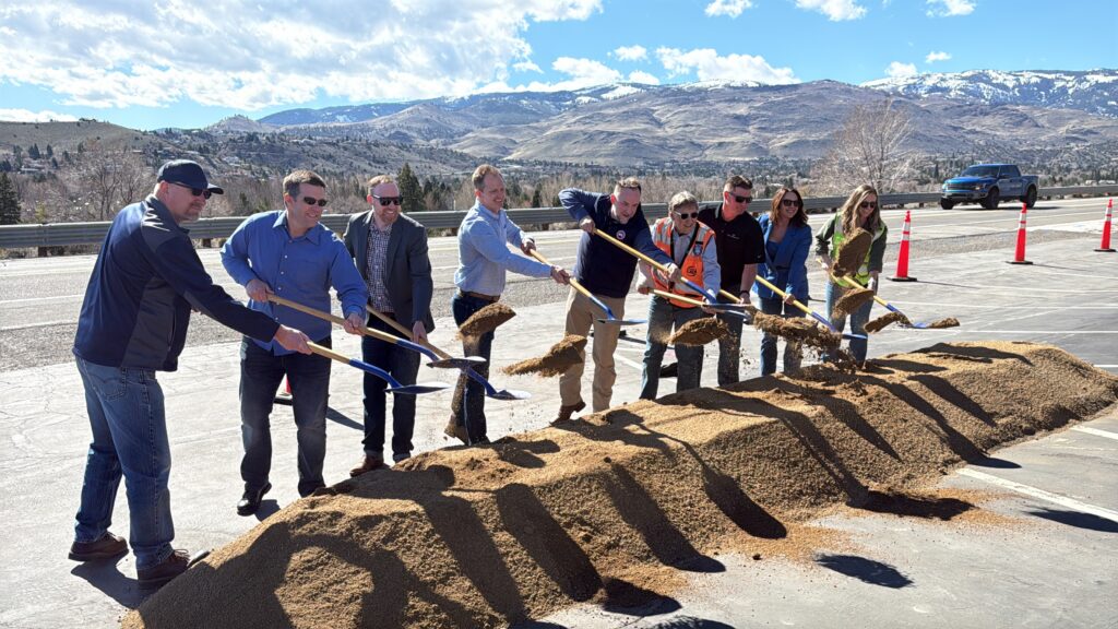 RTC and community partners ceremonially break ground on the West Fourth Street Safety Project on March 2, 2026. A group of approximately ten officials and project team members toss shovelfuls of gravel against a backdrop of snow-capped Sierra Nevada mountains and clear blue skies.